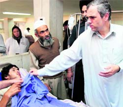 Chief minister Oman Abdullah enquires after an injured at the Sher-e-Kashmir Institute of Medical Sciences in Srinagar on Thursday