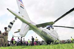 People crowd around JD(U) chief Sharad Yadavs copter that made an emergency landing in Changad village, following a technical snag, in Patna on Thursday.
