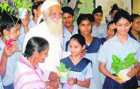 Padma Vibhushan Surinder Lal Bahuguna distributes saplings of medicinal plants among students at Govt Model Senior Secondary School in Chandigarh on Friday.