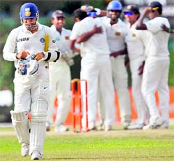 Virender Sehwag (L) walks off the field as Sri Lanka's players celebrate his dismissal during the fourth day of the third and final Test in Colombo on Friday