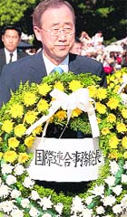 UN Secretary-General Ban Ki-moon carries a wreath to lay down at the cenotaph for the atomic bomb victims at the Peace Memorial Park in Hiroshima on Friday.