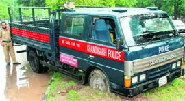 The front wheels of a police van get stuck in mud on the road separating Sectors 9 and 17 in Chandigarh on Saturday