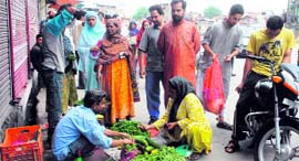 People buy vegetables during curfew relaxation in Srinagar on Saturday.