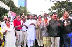 Congress workers take out a candle march in Dehradun on Sunday. 