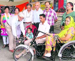 Principal secretary TR Saranga hands over a tricycle and prosthetics to physically challenged persons in Ludhiana on Sunday
