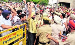 Agitating BEd teachers break a barricade put up by the police in the city on Sunday