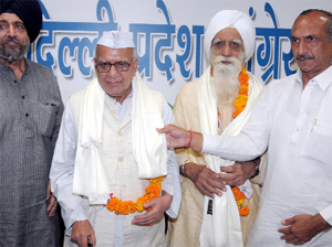 Delhi Pradesh Congress Committee president JP Aggarwal honours freedom fighters to mark Quit India Day at Rajiv Bhawan in New Delhi on Monday.