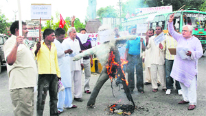 Members of the Akhil Bharatiya Kisan Mahasabha burn an effigy of the government against price rise in Karnal on Monday.
