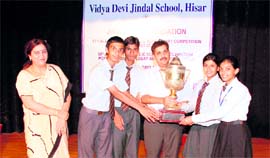 Cartoonist Sandeep Joshi hands over a trophy to students of Choitram School, Indore, who won the declamation competition.
