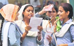 Students cover their heads with handkerchiefs as they rehearse for the Independence Day function in the scorching sun in Ludhiana on Monday. 