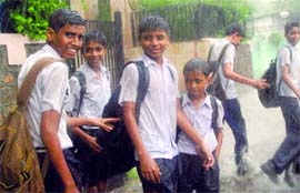 Students enjoy the showers in New Delhi on Tuesday.