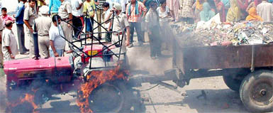 Residents of Ishwar Nagar set a tractor carrying garbage on fire in Amritsar on Tuesday.