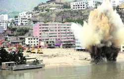 Rescuers conduct an explosion to blast debris damming a river in order to safely release potential flood waters in the mudslides-hit Zhouqu