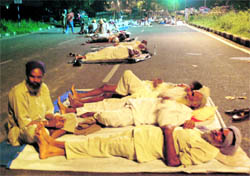 Farmers sleep on a road during their protest on the Chandigarh-Mohali border on Tuesday night