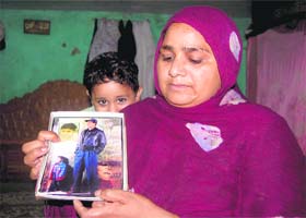 Tahira with a photograph of his husband and daughter in Dehradun