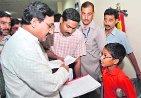 Chief Minister Ramesh Pokhriyal Nishank talks to a physically challenged child in Dehradun
