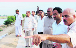 DC CG Rajini Kaanthan (second from right) discusses options for the removal of flood water from Bani village in Sirsa 