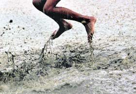 A boy has fun in rainwater in Ludhiana.