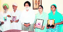 Members of the affected families show photographs of those who were allegedly killed in fake police encounters, in Amritsar on Wednesday. Col GS Sandhu (retd), Chairman, Majha Ex-Servicemen Human Rights Front, is also seen in the picture. 