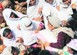 Pakistani flood survivors fight for food bags at an aid distribution point in Nowshera on Wednesday.