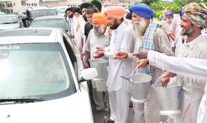 Farmers distribute ‘parshad’ to commuters, trying to make them aware of their demands.
