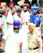 People carry the body of one of the four members of a family murdered in Nabha