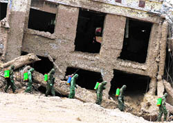 Rescuers disinfect a landslide-hit street in Zhouqu County of Gannan Tibetan Autonomous Prefecture, Gansu Province on Thursday. The risk of fresh downpours threatened more misery on Wednesday for the Chinese town devastated by a landslide and further threatened by an unstable lake behind a barrier of mud