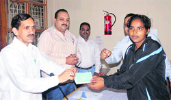 Subhash Barthwal, vice-president, Yuva Kalyan Parishad, presents a cheque to a sportsperson 
