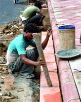 Labourers prepare the footpath near Rajpath in New Delhi.
