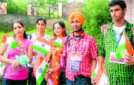 Students of the regional centre of HPU at Dharamsala holding replicas of national flag on the eve of the Independence Day on Saturday