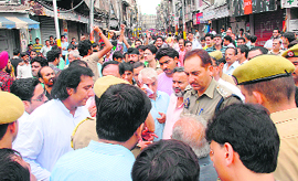 The police tries to pacify shopkeepers of Kanak Mandi who blocked the road leading to the market in Jammu on Saturday.