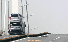 A truck carries cars at a port area in Yokohama, south of Tokyo, on Monday. Japan's economic growth slowed to a crawl in the second quarter and analysts see more weakness ahead, adding to policymakers' headaches as they grapple with deflation and a rise in the yen that threatens an export-reliant recovery.