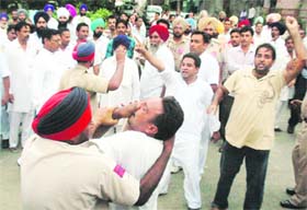 A policeman tries to prevent a teacher from staging a protest at Sukhbir Badals rally in Bathinda
