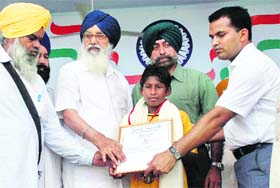 Gurjeevan Singh, who thwarted a bank robbery in Mansa, receives the state award from Chief Minister Parkash Singh Badal on Independence Day in Ferozepur