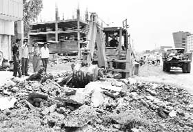 A JCB machine removes an illegal encroachment on the Chandigarh-Ambala highway at Zirakpur