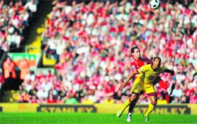 Liverpools maxi Rodriguez (L) fights for the ball with Arsenals Theo Walcott at Anfield