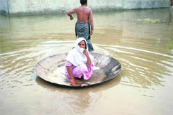 A Pakistani flood survivor floats his mother to a safer area in Khangarh near Multan on Monday.