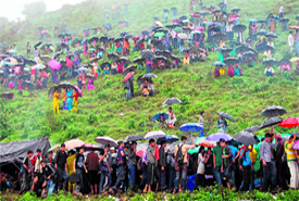 Devotees brave the rain outside the Bhadraj temple in Mussoorie on Tuesday.