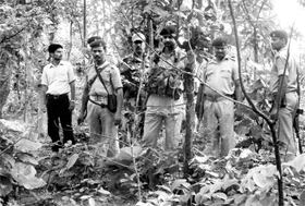 Policemen survey the scene of a Maoist massacre inside a forest in Jharkhand