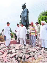 INLD supporters try to stop the demolition of the floor on which the statue of Tau Devi Lal stands as the NHAI wants to use the space for widening the highway