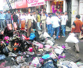 Shopkeepers collecting their remaining goods at Lower Bazaar in Shimla on Tuesday.  Four shops were burnt on Monday night, according to the police. 