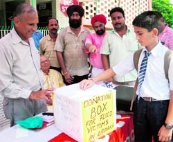 A student donates money for Ladakh flood victims at a relief fund counter