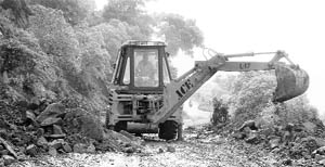 A JCB machine removes boulders from Morni-Panchkula road on Wednesday.