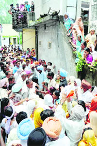 Villagers gather in front of the residences of the victims on the arrival of their bodies at Kansal village in Mohali district on Wednesday.