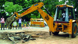 Workers repair a portion of the road that caved in near Rajesh Pilot Marg in New Delhi on Wednesday