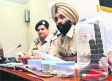 Police officials show a pistol recovered from snatchers on Wednesday.