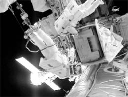 Spacewalkers Doug Wheelock (L) and Tracy Caldwell Dyson work on connections to the spare ammonia coolant pump module on the International Space Station in this NASA TV image