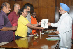 Cartoonist and painter Uday Shankar Ganguly presents the Prime Minister his caricature in New Delhi.