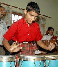 A visually challenged child plays drums during the launch of a computer centre for visually challenged children of AICB Captain Chandanlal Special School for Blind at Behrampur in Gurgaon.