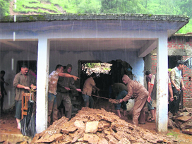 Relief workers take out debris from the school in Sumgarh where 18 students died recently.